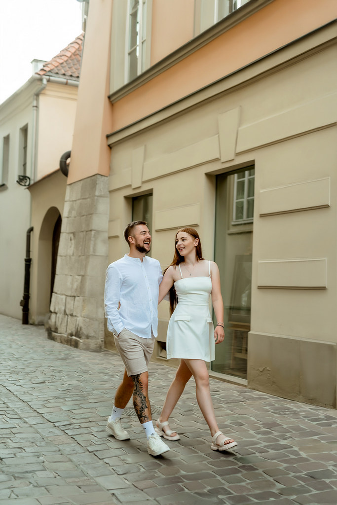 Sesja zdjęciowa pary na starówce Krakowa. Chłopak i dziewczyna spacerują wąskimi uliczkami