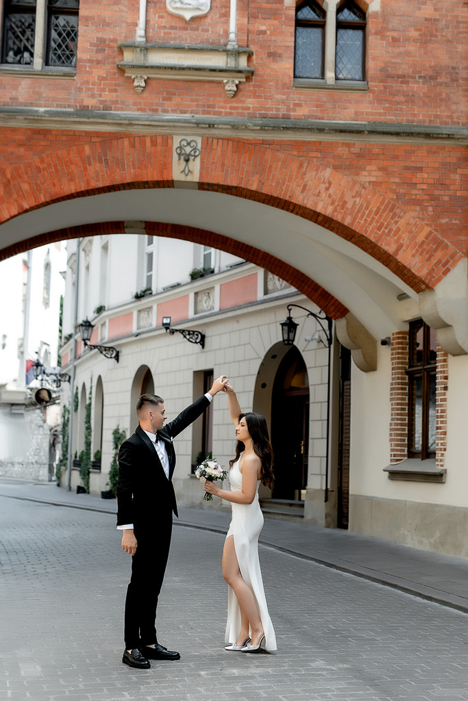 Sesja zdjęciowa dziewczyny na weselu na starym mieście w Krakowie. Dziewczyna spaceruje po ulicach starego miasta wiosną
